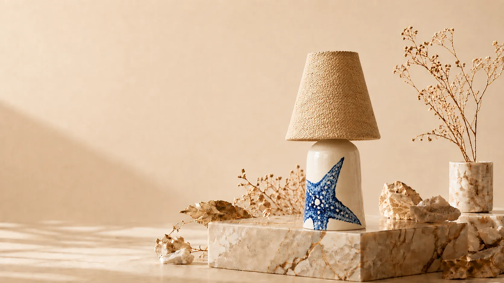 Lámpara de cerámica pintada a mano con una estrella de mar, sobre una peana de mármol
